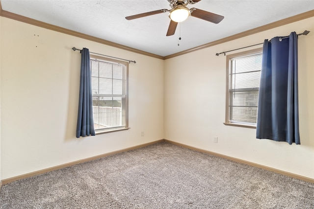 carpeted spare room featuring ceiling fan, ornamental molding, and baseboards
