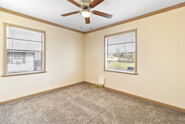carpeted empty room featuring baseboards, ceiling fan, and crown molding
