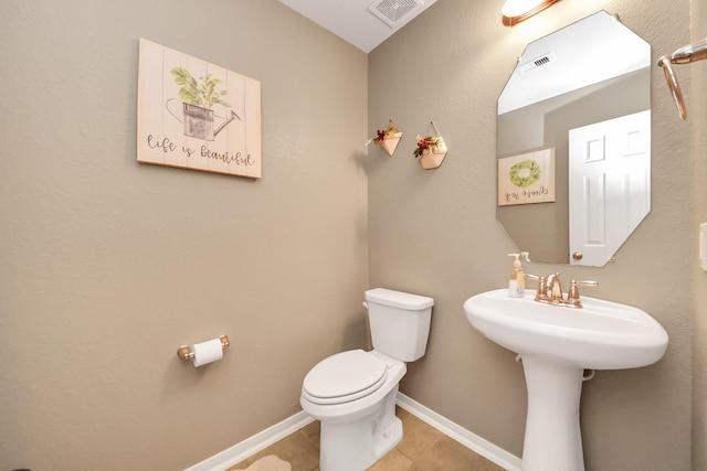 bathroom featuring toilet, tile patterned floors, visible vents, and baseboards