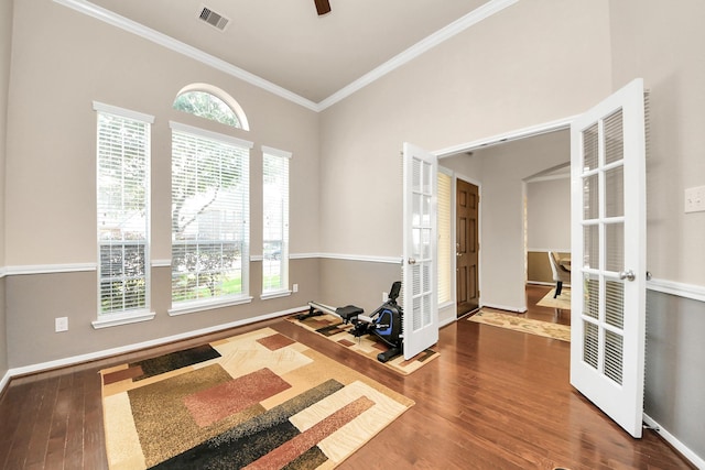 spare room with visible vents, ornamental molding, wood finished floors, french doors, and a wealth of natural light