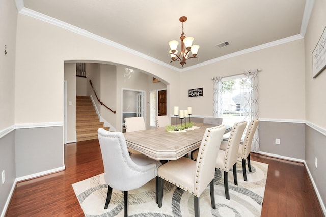dining area featuring arched walkways, baseboards, wood finished floors, and a notable chandelier