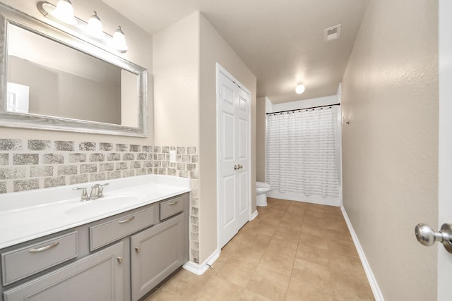 bathroom featuring baseboards, tile patterned floors, vanity, and toilet