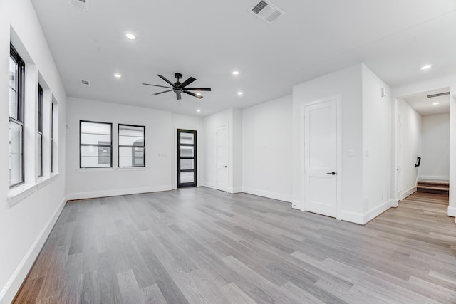 spare room with baseboards, visible vents, a ceiling fan, and light wood-style flooring
