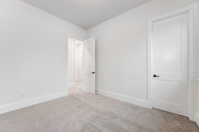 unfurnished room featuring carpet and baseboards