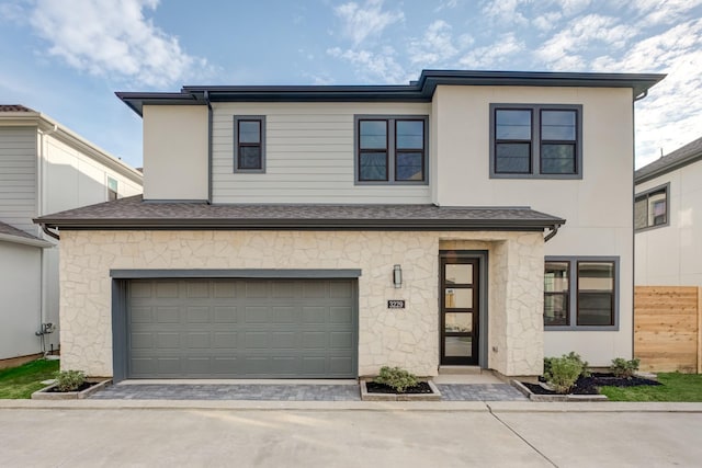 view of front of house with a garage, driveway, and stone siding