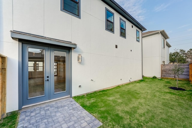 rear view of house featuring fence, a lawn, a patio area, and french doors