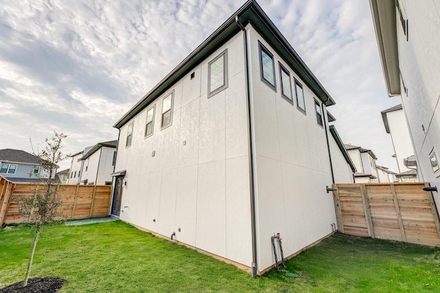 rear view of house with a lawn and a fenced backyard