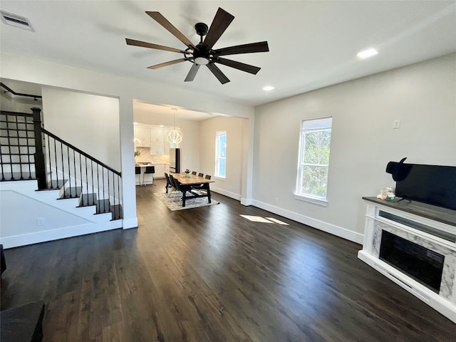 13505 Orleans St, Houston, TX 77015 - living area with a premium fireplace, dark wood-style flooring, baseboards, ceiling fan, and stairway