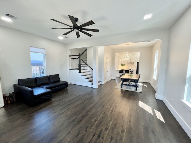 13505 Orleans St, Houston, TX 77015 - living room with stairway, dark wood finished floors, baseboards, and ceiling fan
