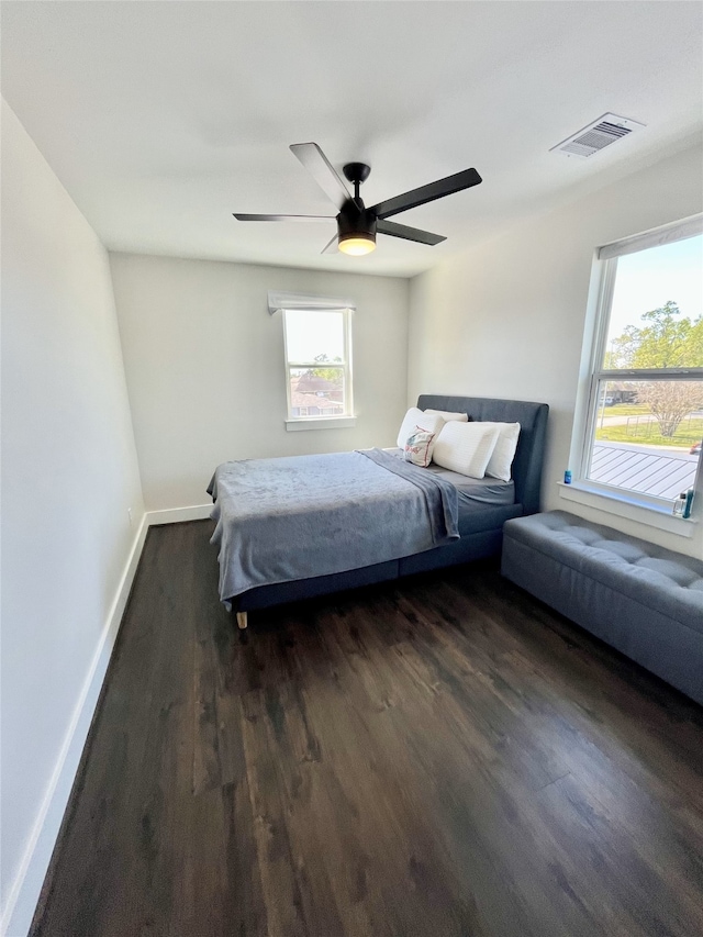 13505 Orleans St, Houston, TX 77015 - bedroom featuring dark wood-style floors, multiple windows, baseboards, and ceiling fan