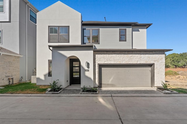 view of front of property with stucco siding, concrete driveway, and an attached garage