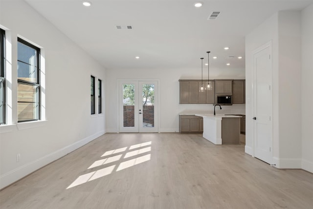unfurnished living room featuring recessed lighting, french doors, and light wood-style floors