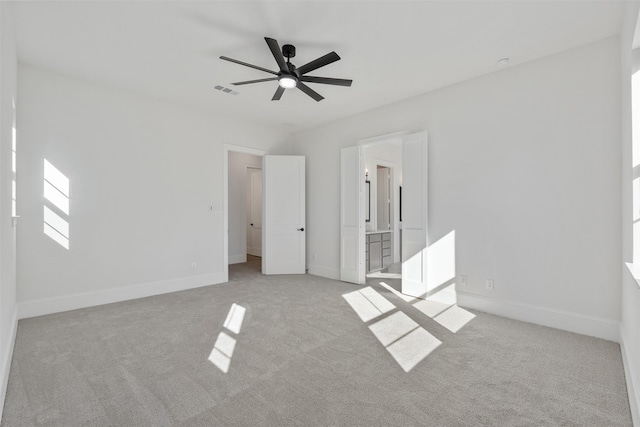 unfurnished bedroom featuring connected bathroom, carpet flooring, visible vents, ceiling fan, and baseboards