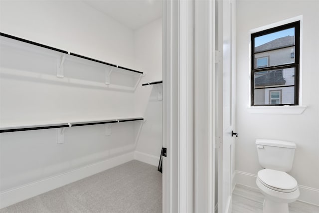 interior space with baseboards and toilet