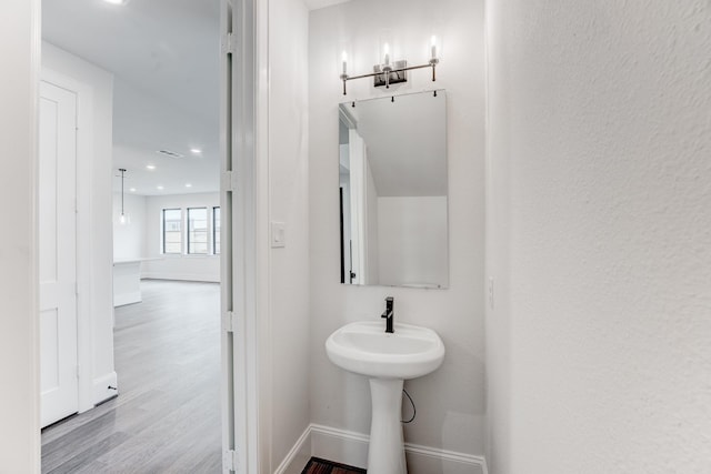 bathroom with baseboards, recessed lighting, and wood finished floors