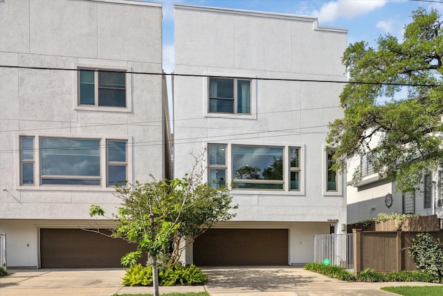 1946 Vermont St, Houston, TX 77019 - view of property with an attached garage, stucco siding, and concrete driveway