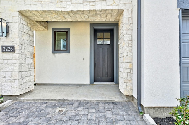 view of exterior entry featuring stone siding