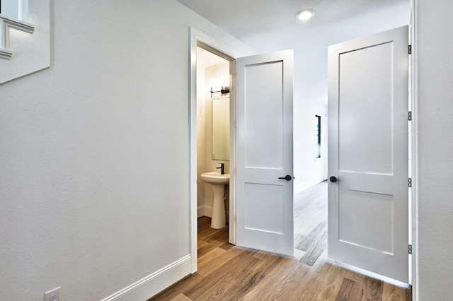 corridor with wood finished floors and baseboards