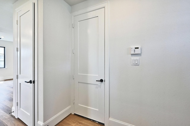 hallway featuring baseboards and light wood-type flooring