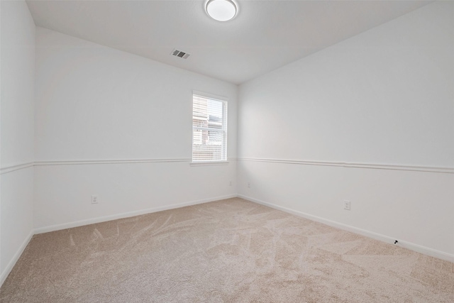 empty room featuring visible vents, baseboards, and carpet floors