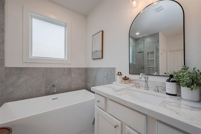 full bath featuring a freestanding tub, visible vents, vanity, and a stall shower