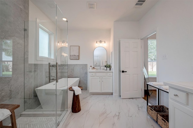 bathroom featuring a shower stall, vanity, marble finish floor, visible vents, and a soaking tub