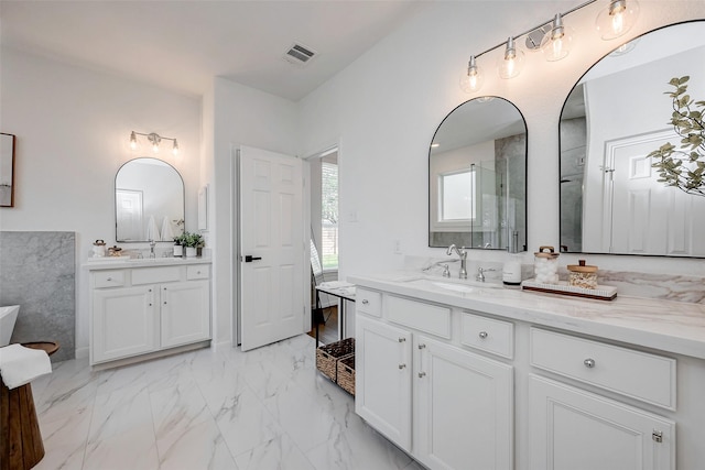 bathroom featuring a stall shower, two vanities, a sink, and visible vents