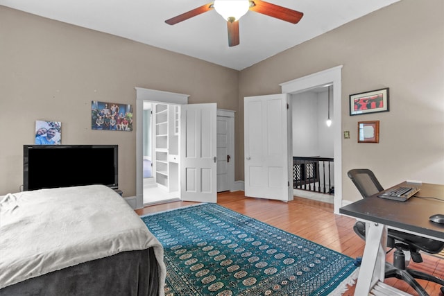 bedroom with wood finished floors, a ceiling fan, and baseboards