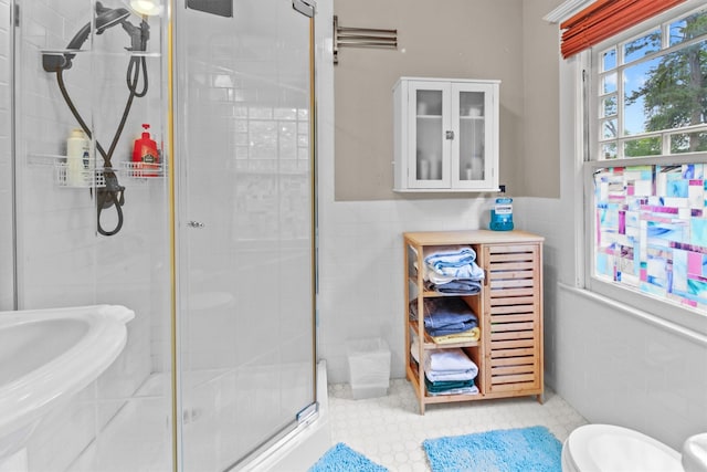 bathroom with tile walls, a wainscoted wall, a shower stall, and toilet