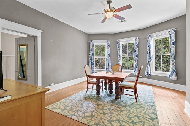 dining room with light wood-type flooring, visible vents, a healthy amount of sunlight, and a ceiling fan