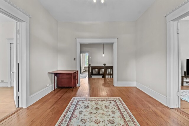 hallway featuring light wood-style floors and baseboards