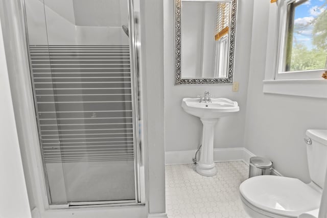 full bathroom featuring tile patterned floors, toilet, a shower stall, and baseboards