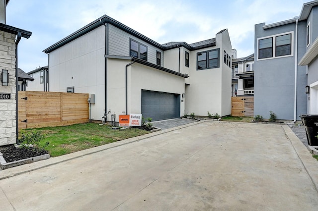 view of property exterior featuring fence, stucco siding, and a garage