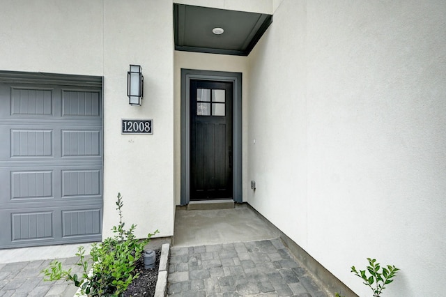view of exterior entry featuring stucco siding