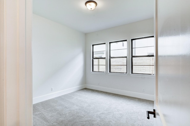 carpeted empty room with baseboards