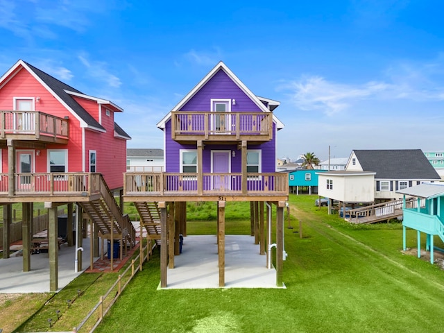 rear view of property with a patio, a carport, a wooden deck, and a lawn