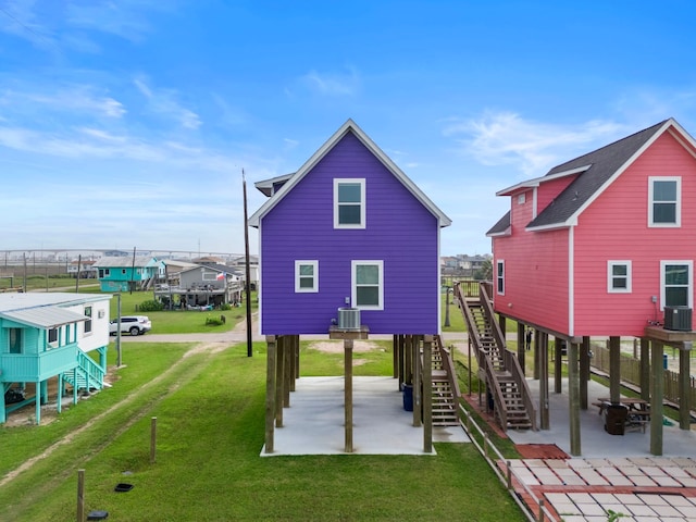 view of jungle gym with a lawn, central AC unit, stairs, and a patio area