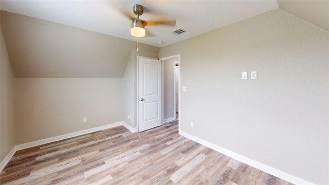 additional living space featuring visible vents, ceiling fan, light wood-style flooring, and vaulted ceiling