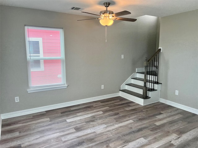 511 Caisson St, Surfside Beach, TX 77541 - unfurnished living room featuring wood finished floors, ceiling fan, baseboards, and stairway