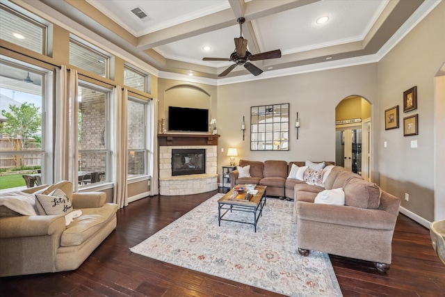 living area featuring crown molding, dark wood-style flooring, a fireplace, arched walkways, and coffered ceiling