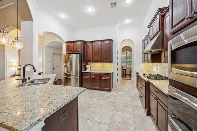 kitchen featuring crown molding, visible vents, a sink, arched walkways, and appliances with stainless steel finishes