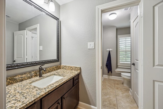 bathroom featuring toilet, tile patterned floors, baseboards, and vanity