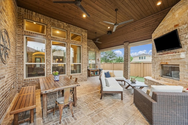 view of patio / terrace featuring fence, a ceiling fan, and an outdoor living space with a fireplace