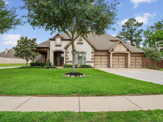 view of front of home featuring an attached garage, driveway, a front yard, and stone siding