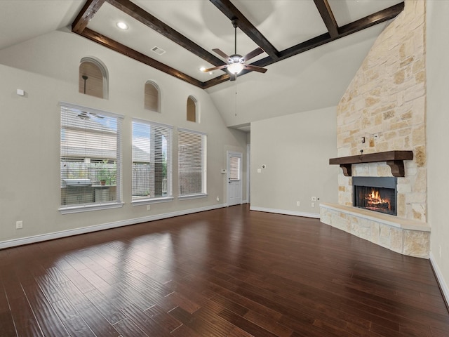 unfurnished living room featuring ceiling fan, a stone fireplace, baseboards, wood finished floors, and visible vents