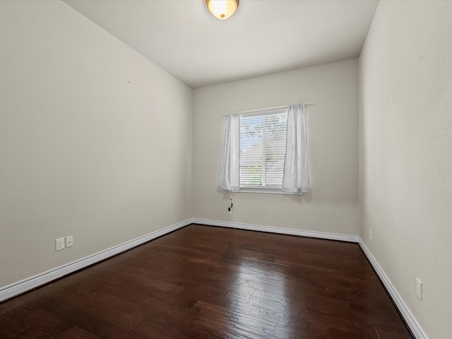 unfurnished room featuring baseboards and wood finished floors