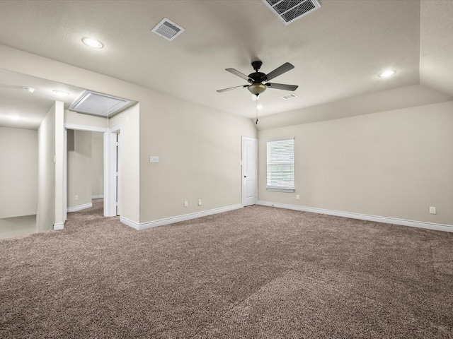 spare room with ceiling fan, attic access, carpet flooring, and visible vents
