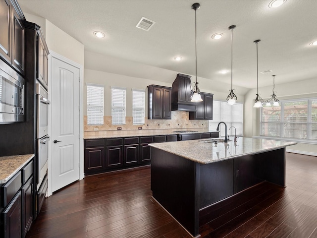 kitchen featuring visible vents, a sink, dark wood-style flooring, and stainless steel appliances