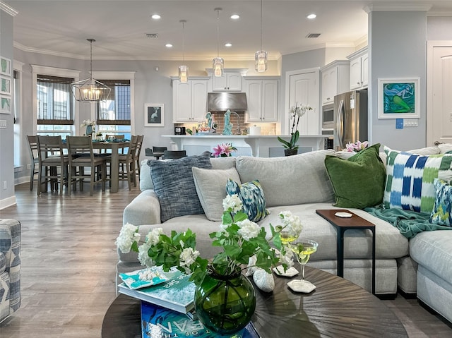 living area with visible vents, ornamental molding, recessed lighting, and light wood finished floors