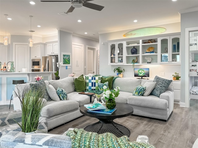 living area featuring crown molding, light wood finished floors, a ceiling fan, and recessed lighting